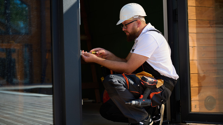 Construction worker installing door in a new house