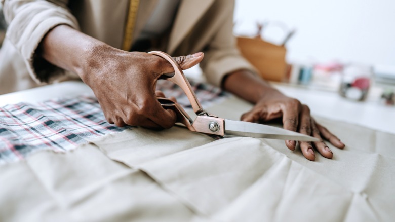 person cutting linen fabric with sheers