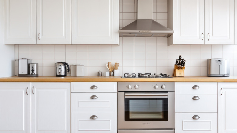 a builder grade range hood in a plain white kitchen