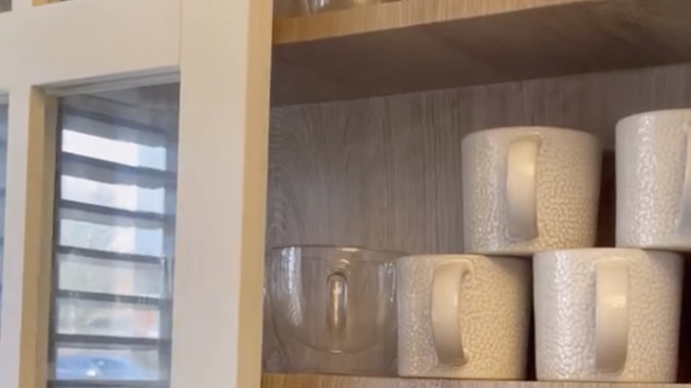 An old CD rack houses coffee mugs