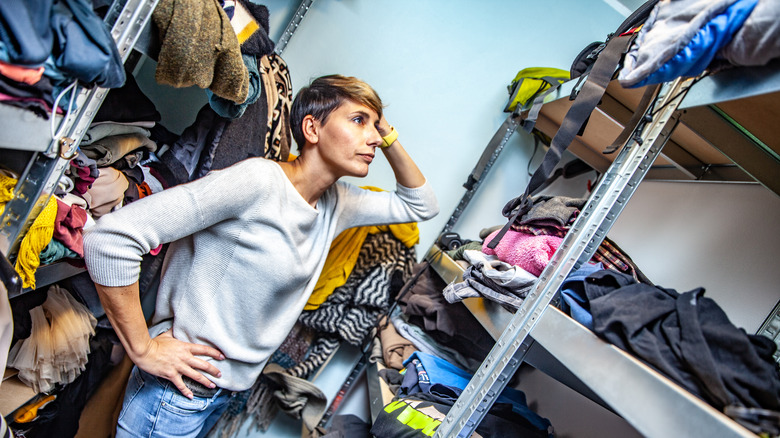 Woman overwhelmed by overflowing closet