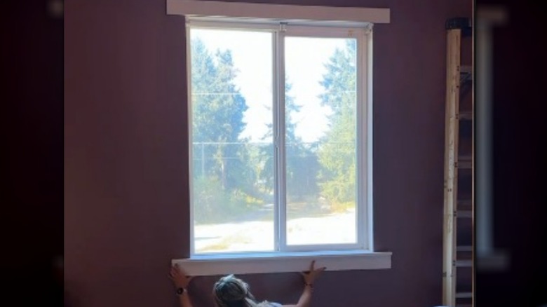 Person installing window trim