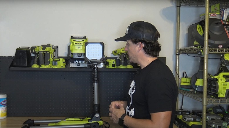 Man setting up the Ryobi tripod LED light