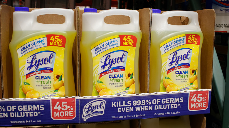 Multiple bottles of Lysol multi-surface cleaner on the shelf of a store.