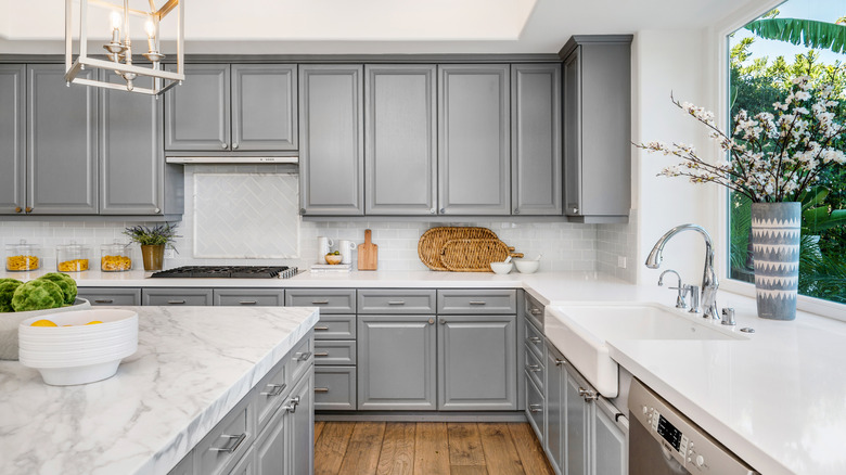Kitchen with gray cabinets and white countertops