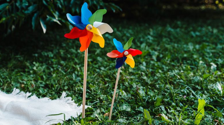 Two multicolored pinwheels against green grass