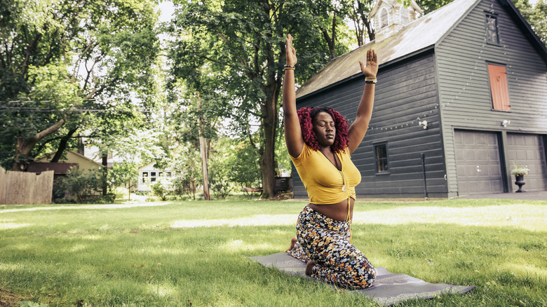 Person stretching on grass in backyard