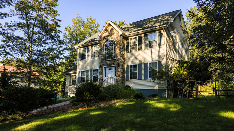 A house, shaded by large trees.