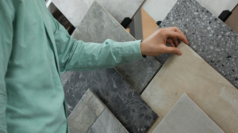 Close-up of a man browsing tile samples at a showroom
