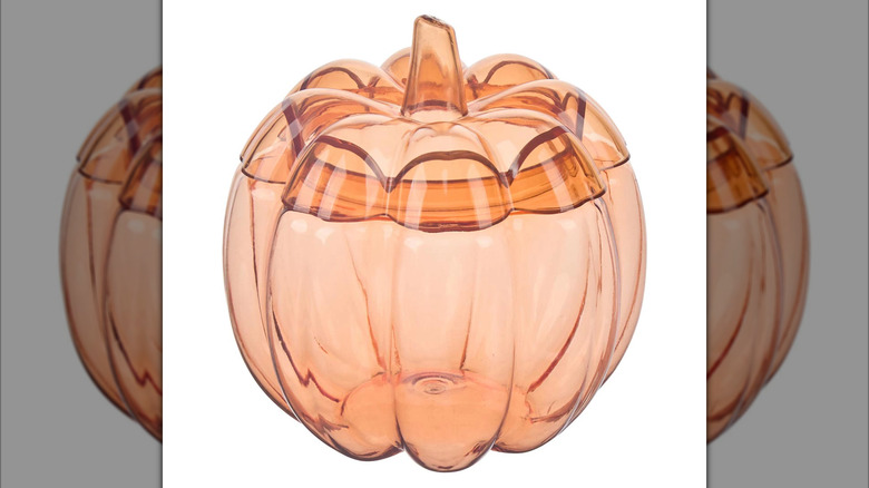 A clear pumpkin jar on display in front of a white background.