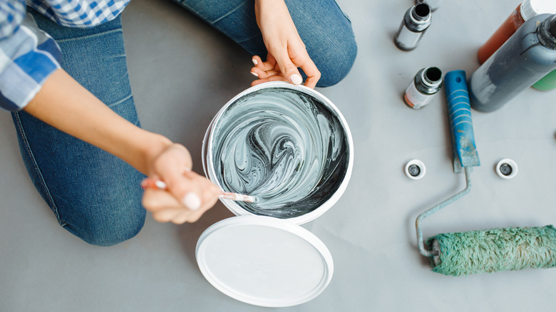 Person mixing two paint colors