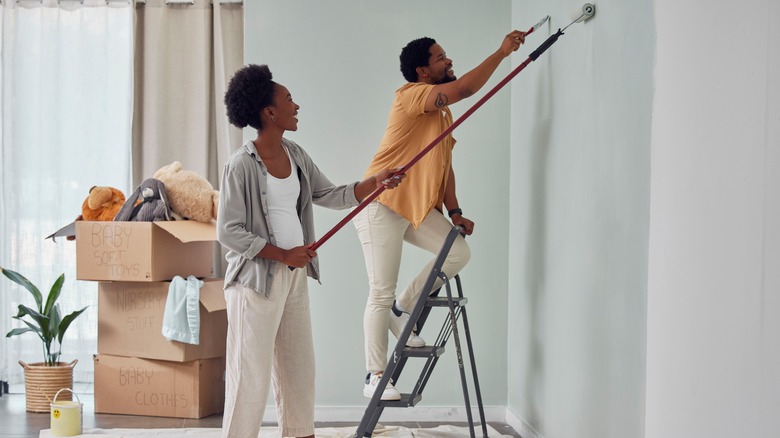 Smiling couple painting walls