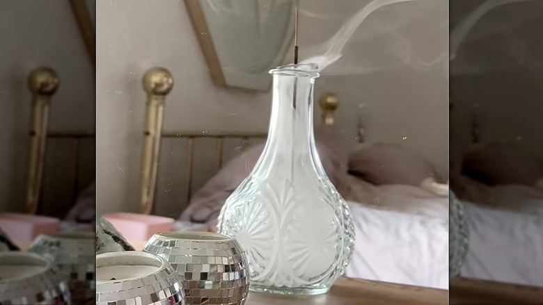 a beautiful crystal decanter being used as an incense burner