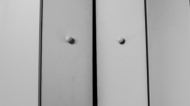 A close up of white bifold closet doors.