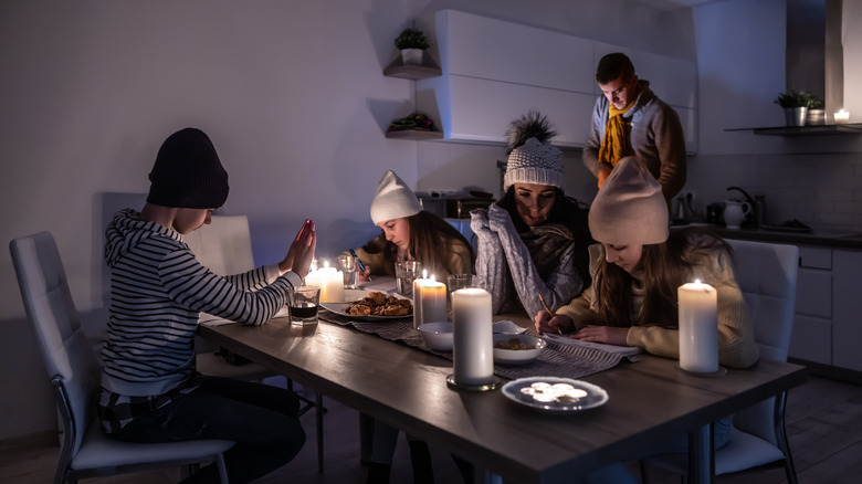 family using candles for light in power outage