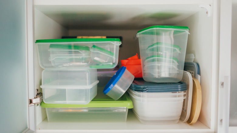 cluttered cabinet with food storage containers