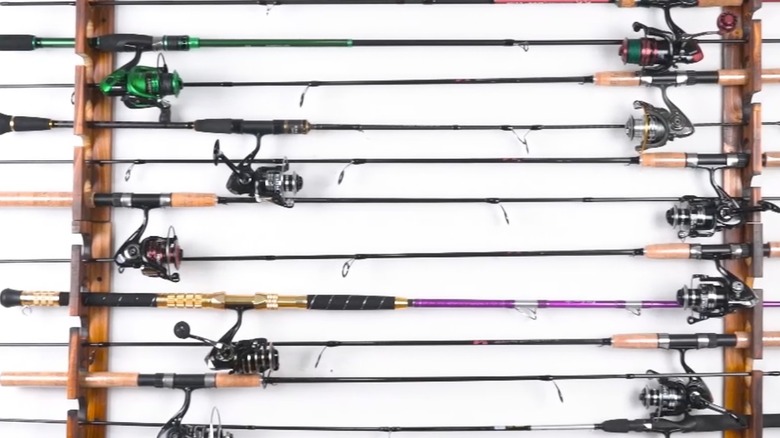 Wood fishing pole racks holding many fishing rods.