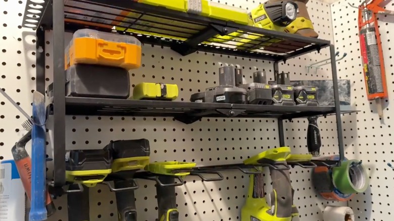 Wall tool organizer holding drills and accessories.