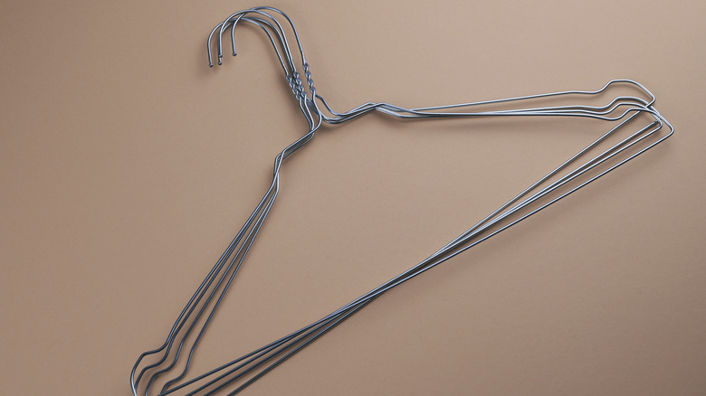 several metal coat hangers on a beige background