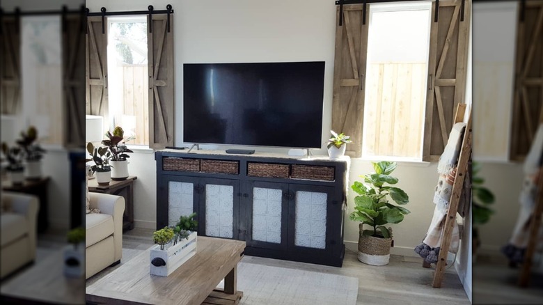 Barn door window shutters on windows flanking an entertainment console