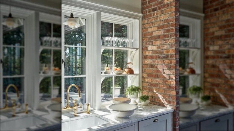 Shelves over kitchen window holding dishes and decor
