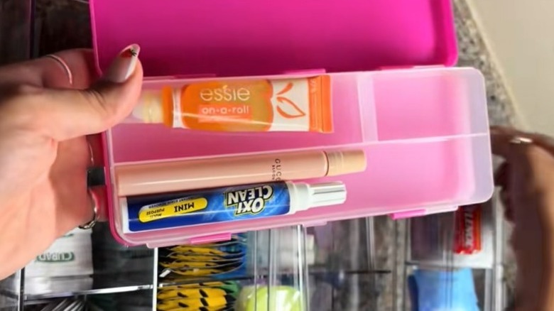 Pencil box with compartments organizing lip balm, travel sized perfume, oxi clean spot cleaner, and gum