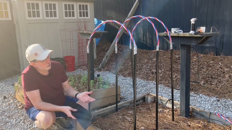 Framework for a row cover using broom handles and sections of hula hoops.