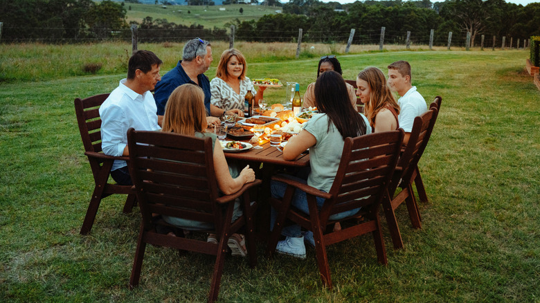 Family gathered around a table outside
