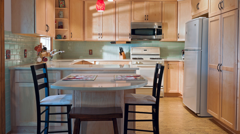 Neutral kitchen with light wooden cabinets and cork floors