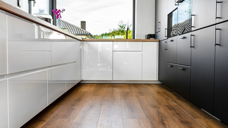 Kitchen with white and black cabinets and vinyl plank flooring