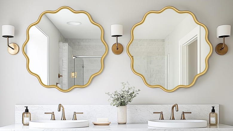 Two gold flower mirrors in a modern bathroom.
