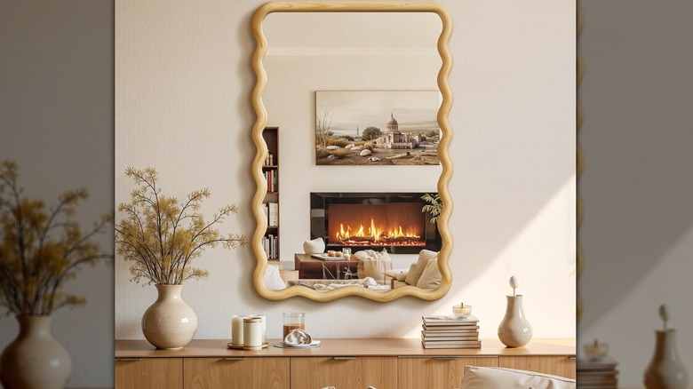 A wooden wall mirror with a wavy frame.