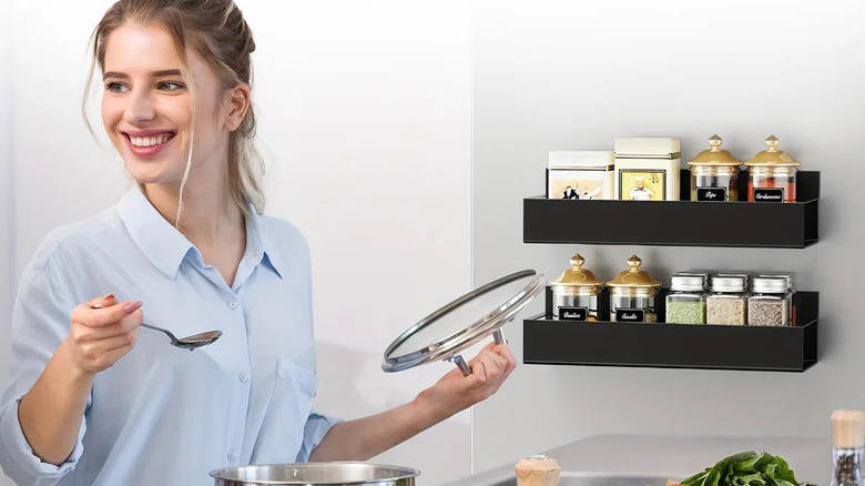 Woman standing beside a magnetic rack filled with spices