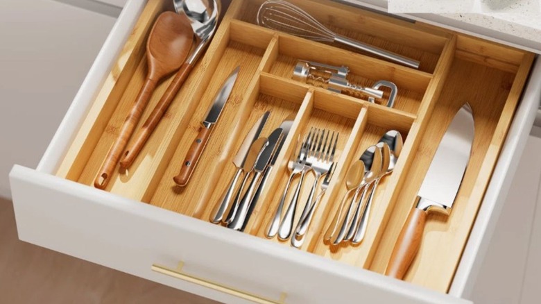 Silverware drawer organizer filled with utensils
