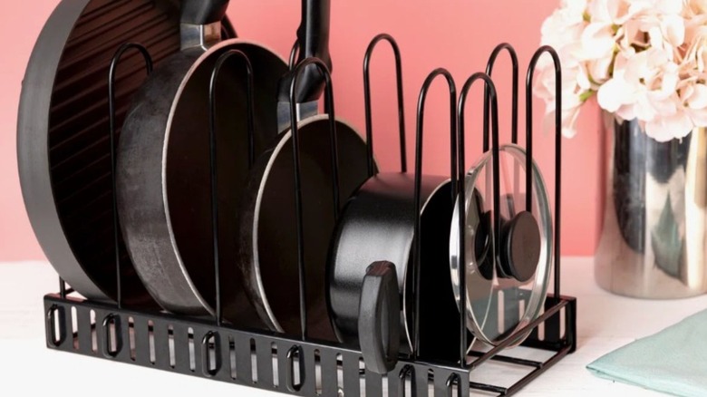 Pot rack filled with pots, pans and lids on counter