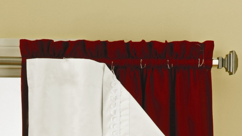 White blackout curtain liners attached to red curtains