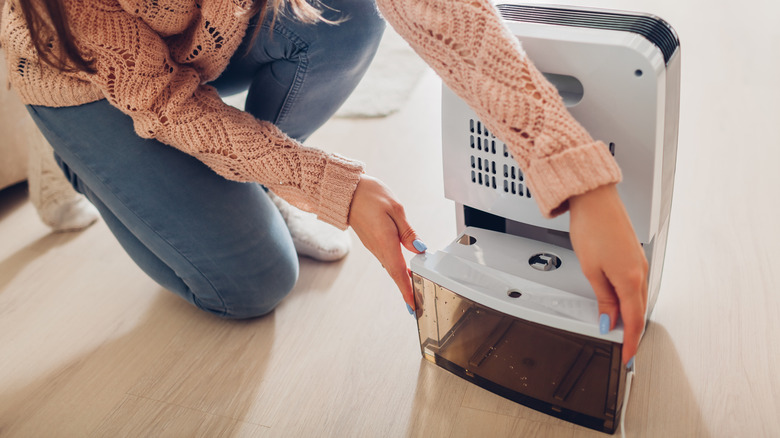 woman setting up a dehumidifier