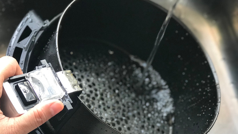 Person cleaning air fryer