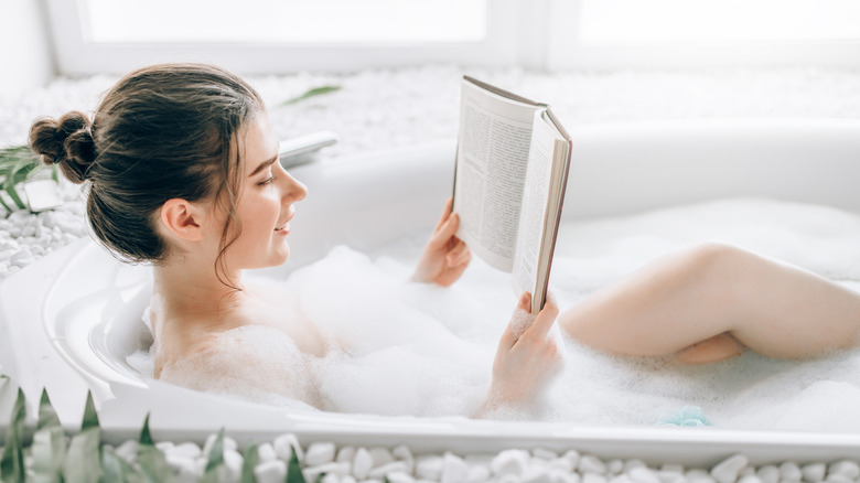 Woman lying in bathtub