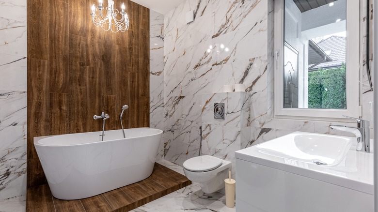 Wide view of modern, luxurious bathroom with sink, bath, and toilet