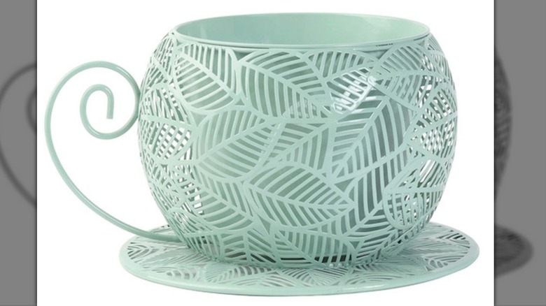 A metal planter in the shape of a tea cup