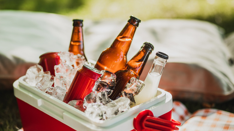 small red cooler filled with ice and various drinks