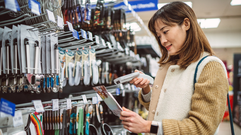 Woman shopping the kitchen utensil aisle of a store