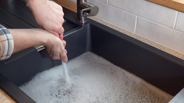 person fixing blocked drain