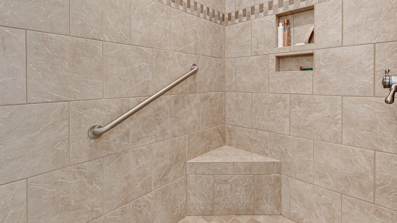 A shower with a grab bar and bench