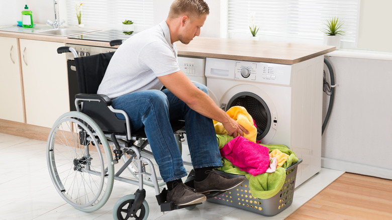 Man in wheelchair doing laundry