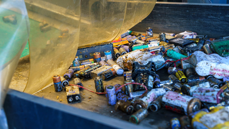 Old batteries on a conveyor belt at a recycling facility
