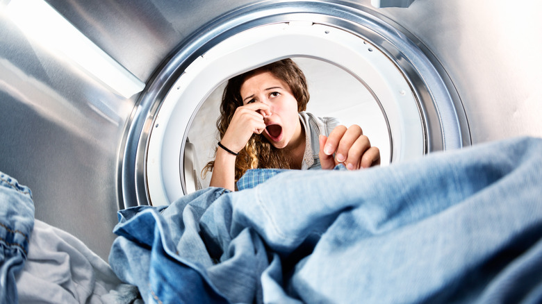 Woman smelling odorous clothing