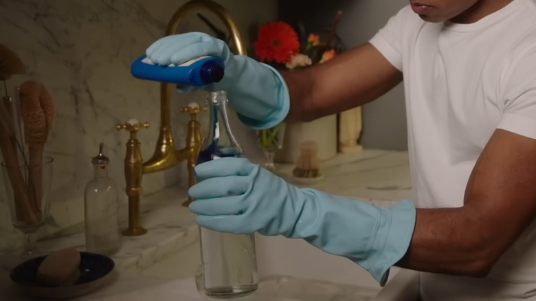 Man adding bluing agent to a bottle of water