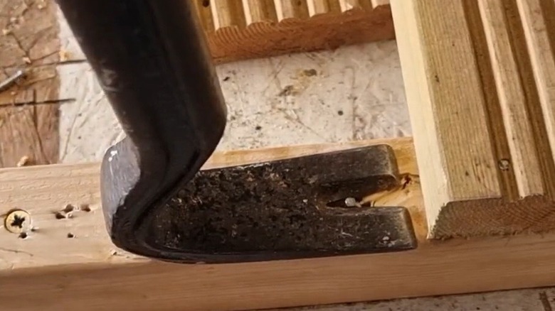 Person using a pry bar with a nail puller